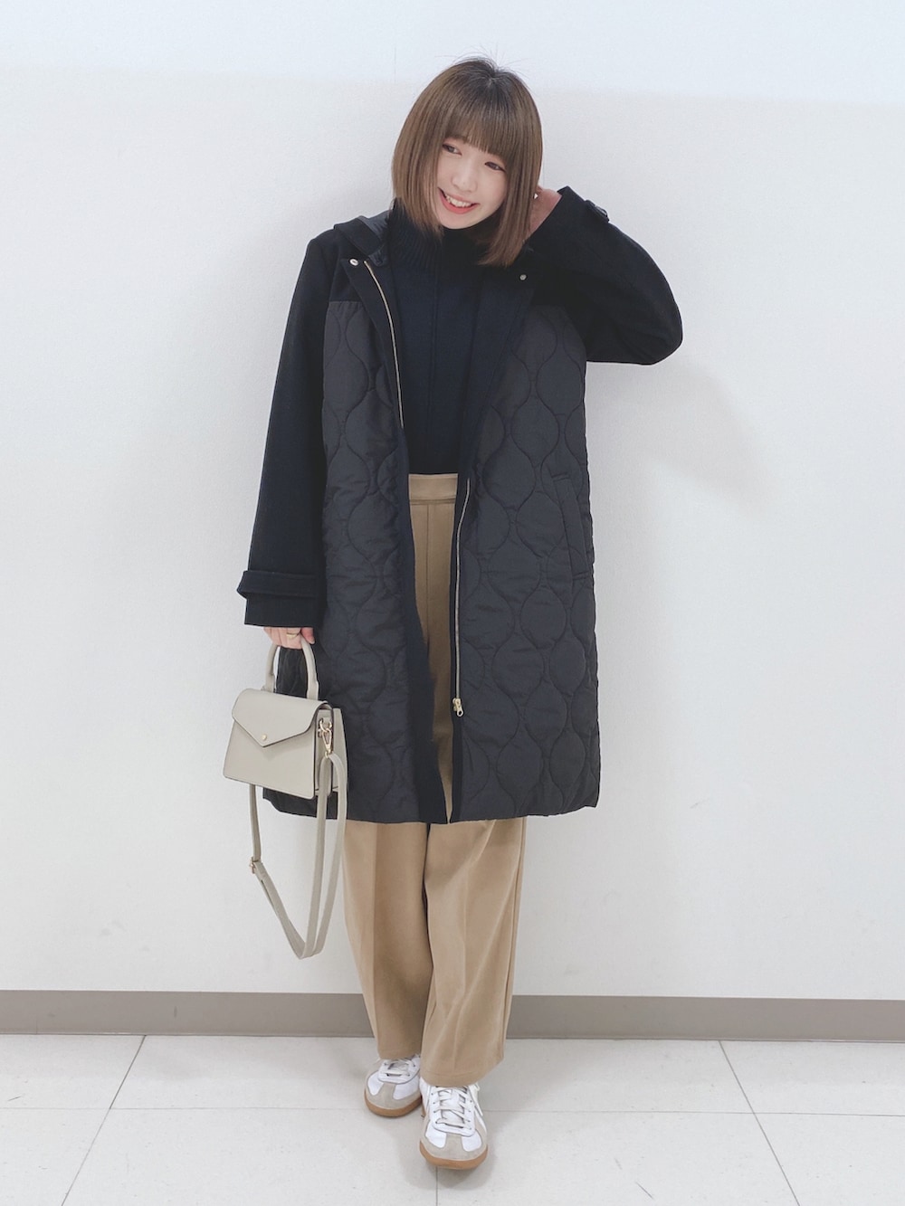 ブラック系のニット/セーター、ブラック系のその他アウター、ベージュ系のその他パンツを着用したレディースの冬コーディネートの4枚目の写真