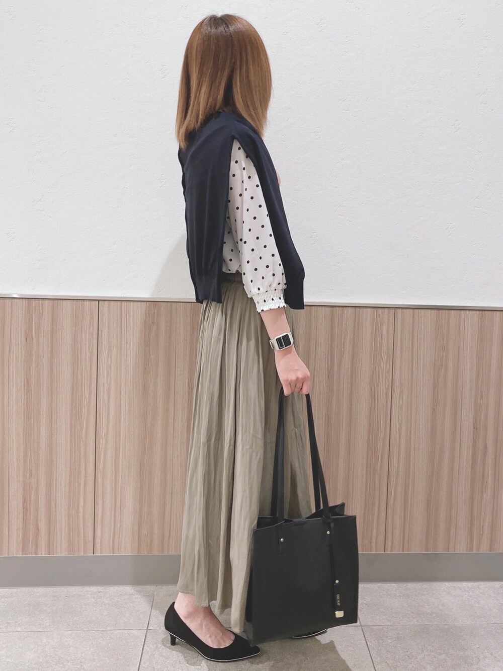 ホワイト系のシャツ/ブラウス、ブラック系のカーディガン/ボレロ、グリーン系のスカートを着用したレディースの春コーディネートの2枚目の写真