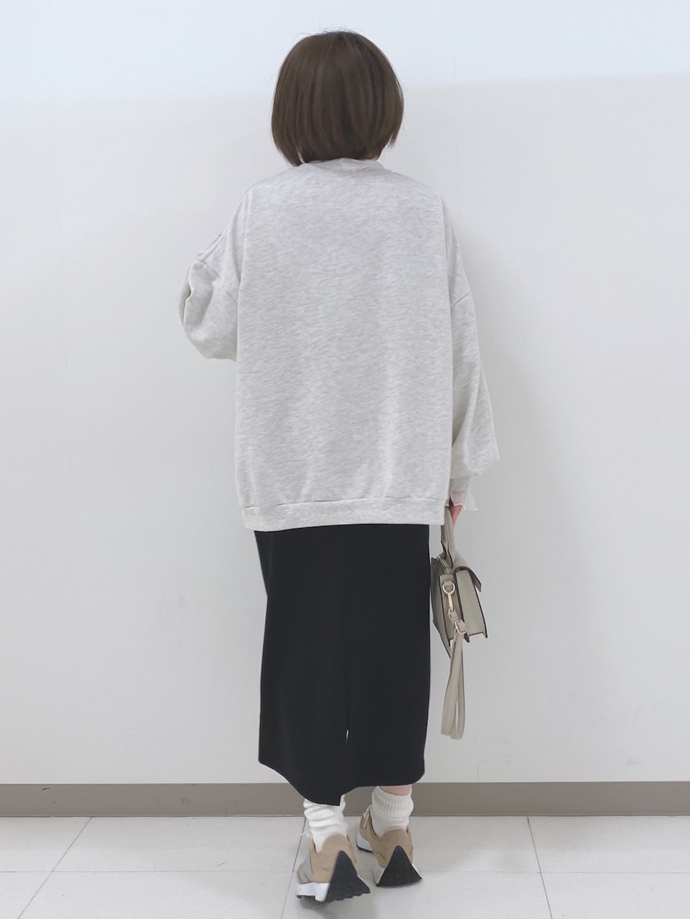 グレー系のスウェット、ホワイト系のTシャツ/カットソー、ブラック系のスカートを着用したレディースの秋コーディネートの3枚目の写真