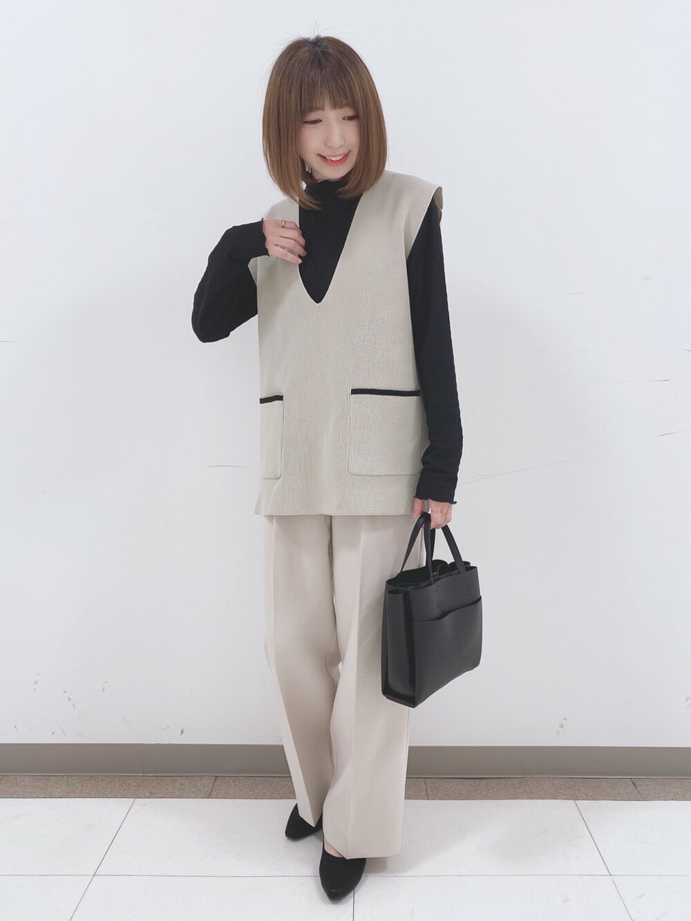 ベージュ系のベスト、ブラック系のTシャツ/カットソー、ベージュ系のその他パンツを着用したレディースの冬コーディネートの4枚目の写真