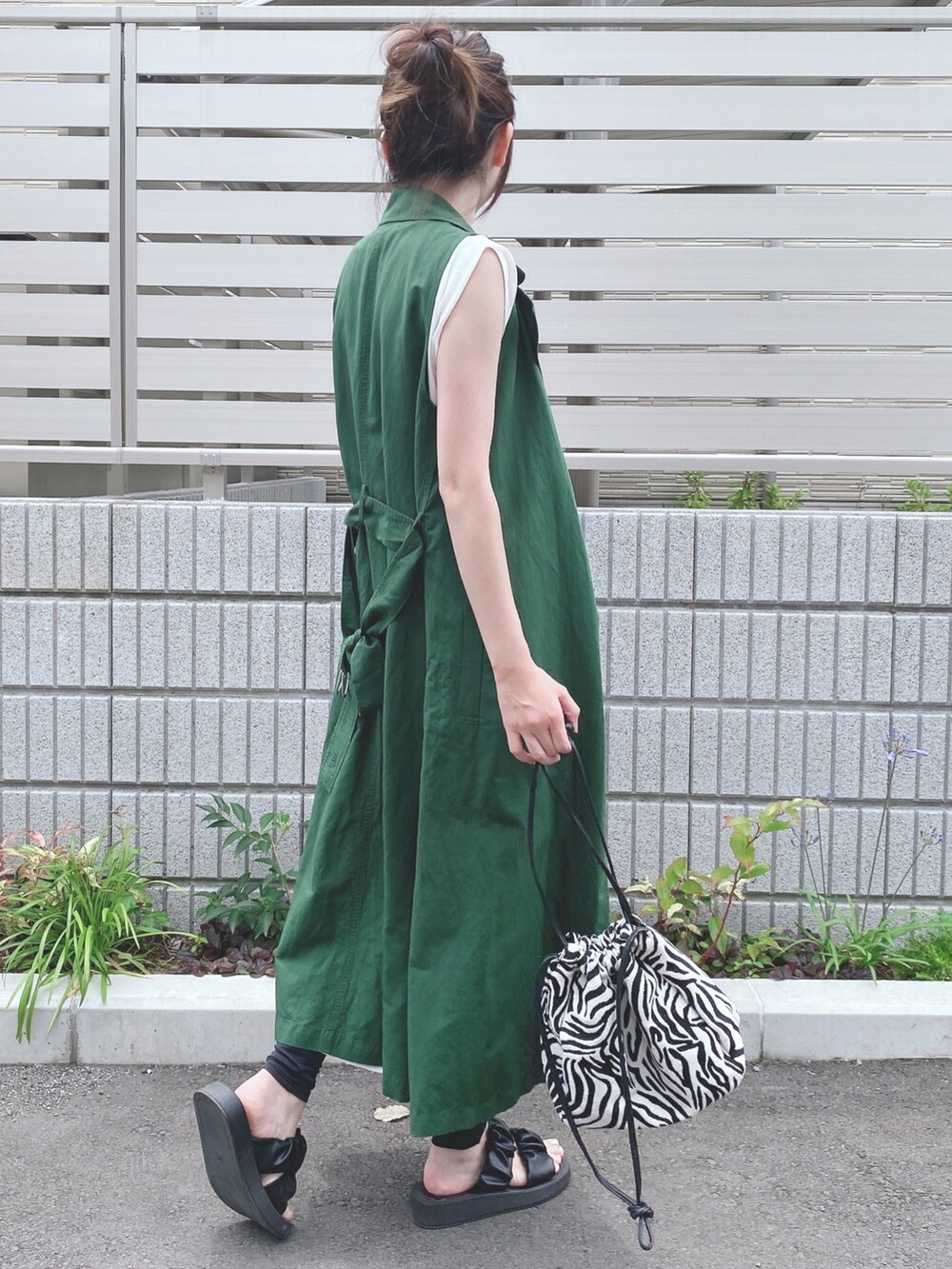 ホワイト系のワンピース、グリーン系のその他アウター、ブラック系のサンダルを着用したレディースの夏コーディネートの2枚目の写真