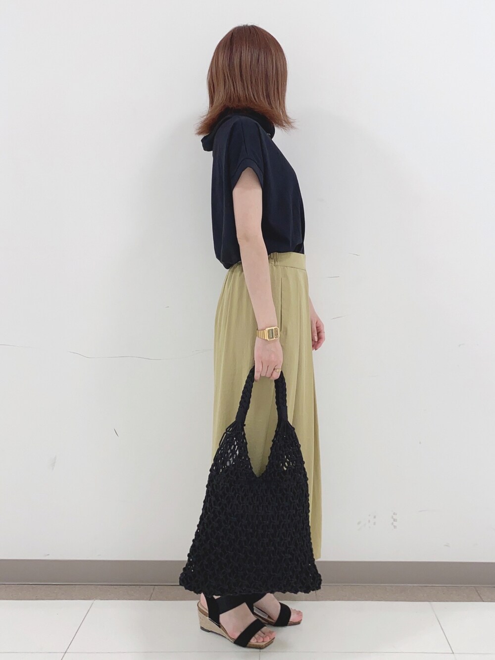 ブラック系のTシャツ/カットソー、イエロー系のその他パンツ、ブラック系のサンダルを着用したレディースの春コーディネートの2枚目の写真