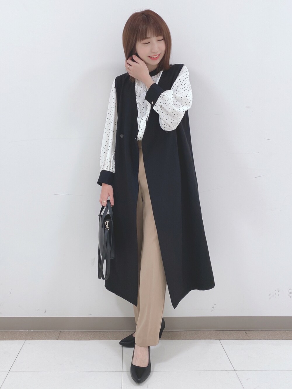 ホワイト系のシャツ/ブラウス、ブラック系のベスト、ベージュ系のその他パンツを着用したレディースの春コーディネートの4枚目の写真