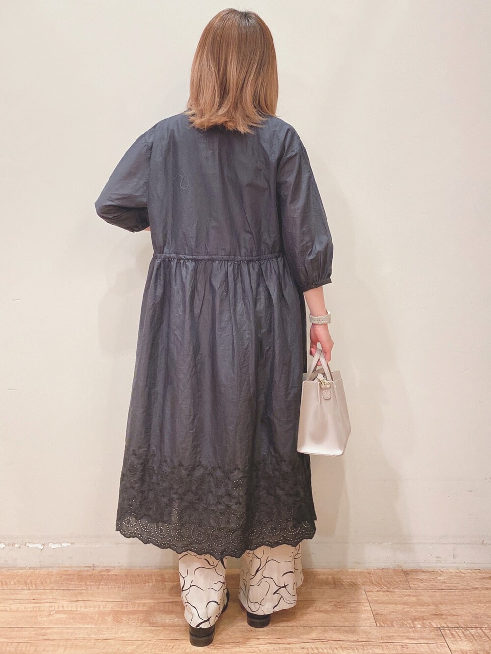 グリーン系のタンクトップ、ブラック系のワンピース、ベージュ系のその他パンツを着用したレディースの春コーディネートの3枚目の写真