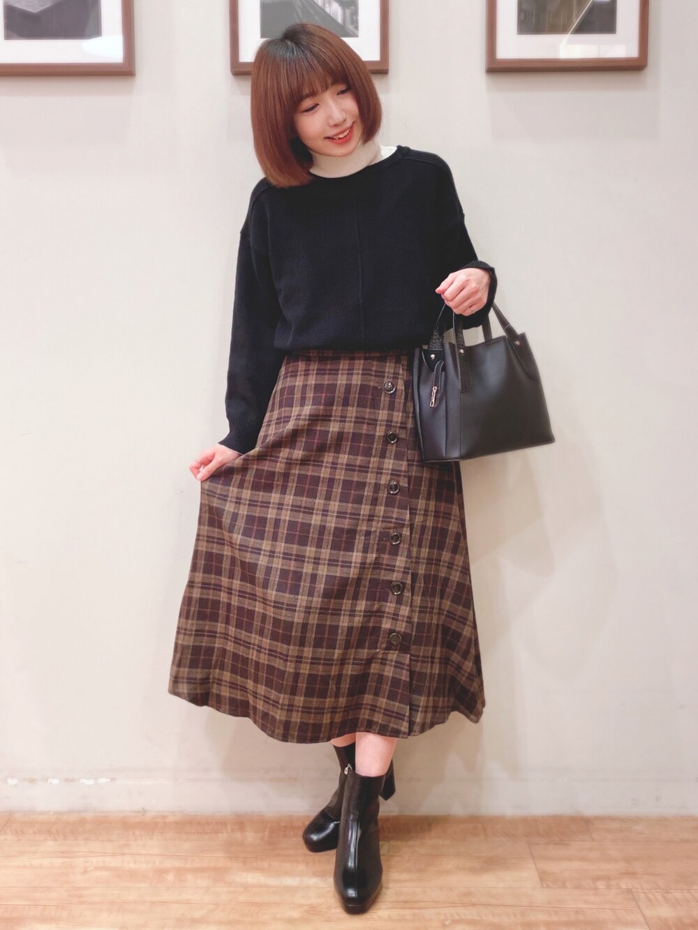 ブラック系のニット/セーター、ブラウン系のスカート、ブラック系のトートバッグを着用したレディースの秋コーディネートの3枚目の写真