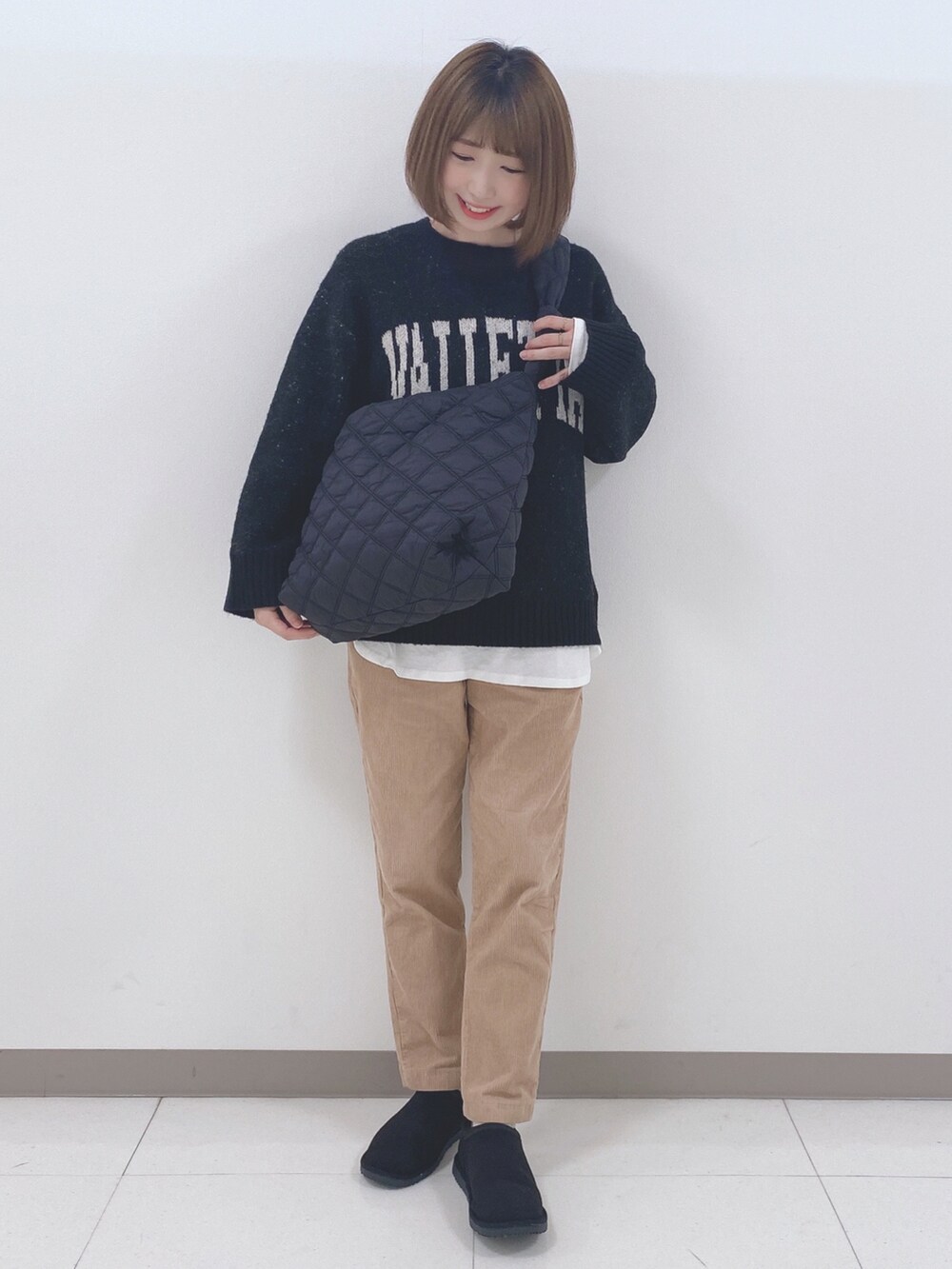 ブラック系のニット/セーター、ホワイト系のTシャツ/カットソー、イエロー系のその他パンツを着用したレディースの秋コーディネートの4枚目の写真