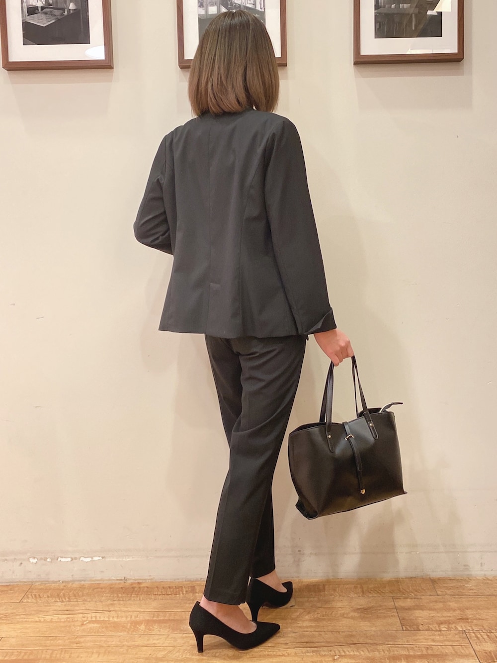 ブラック系のノーカラージャケット、ホワイト系のシャツ/ブラウス、ブラック系のトートバッグを着用したレディースの冬コーディネートの2枚目の写真