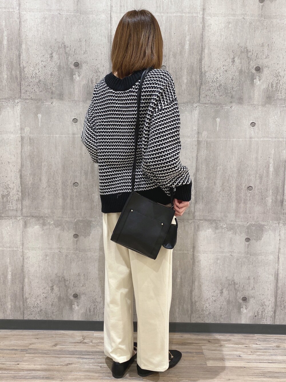 ブラック系のカーディガン/ボレロ、ブラック系のショルダーバッグ、ホワイト系のその他パンツを着用したレディースの冬コーディネートの2枚目の写真