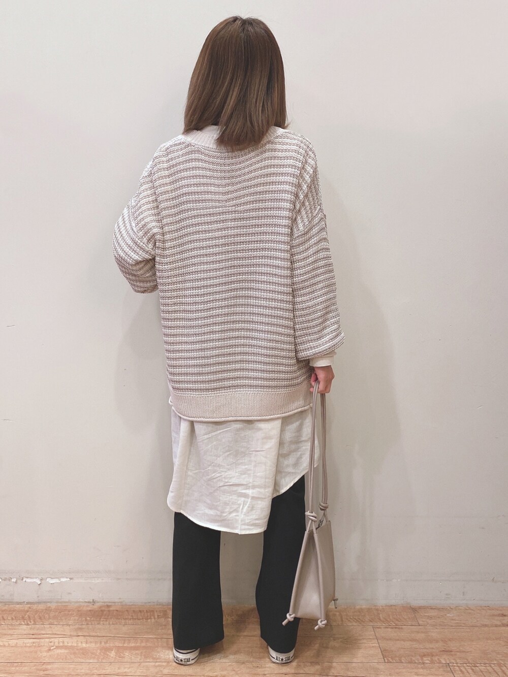 ホワイト系のワンピース、ホワイト系のカーディガン/ボレロ、ホワイト系のスニーカーを着用したレディースの春コーディネートの3枚目の写真