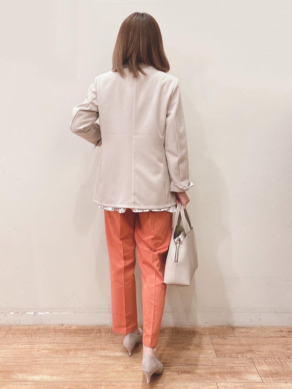 ベージュ系のテーラードジャケット、グレー系のトートバッグ、オレンジ系のその他パンツを着用したレディースの春コーディネートの3枚目の写真