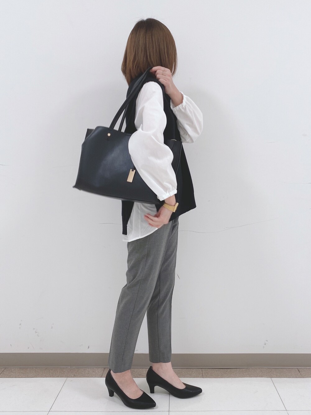 ブラック系のTシャツ/カットソー、グレー系のその他パンツ、ブラック系のパンプスを着用したレディースの冬コーディネートの2枚目の写真