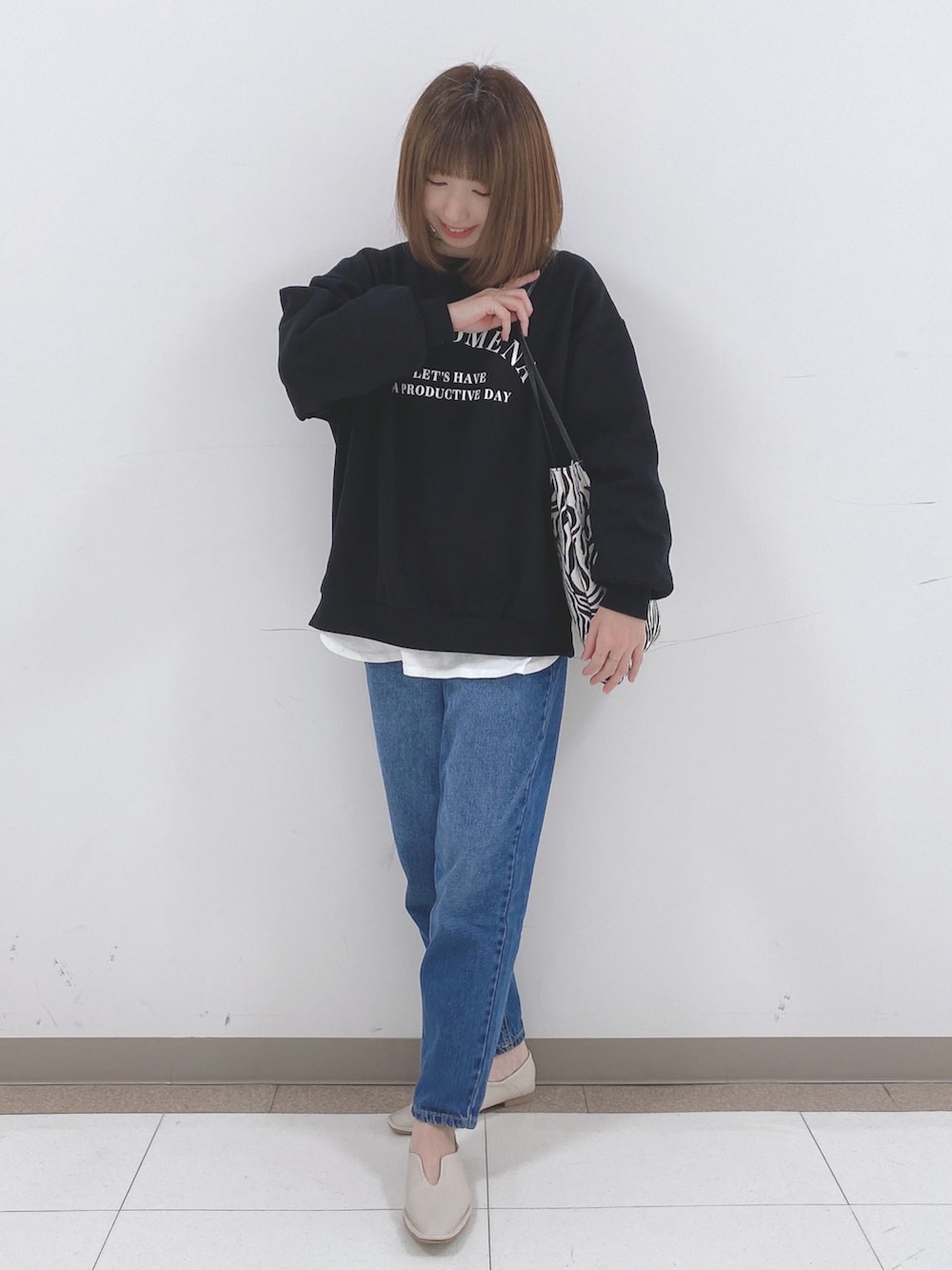 ブラック系のスウェット、ホワイト系のTシャツ/カットソー、ブルー系のデニムパンツを着用したレディースの冬コーディネートの4枚目の写真