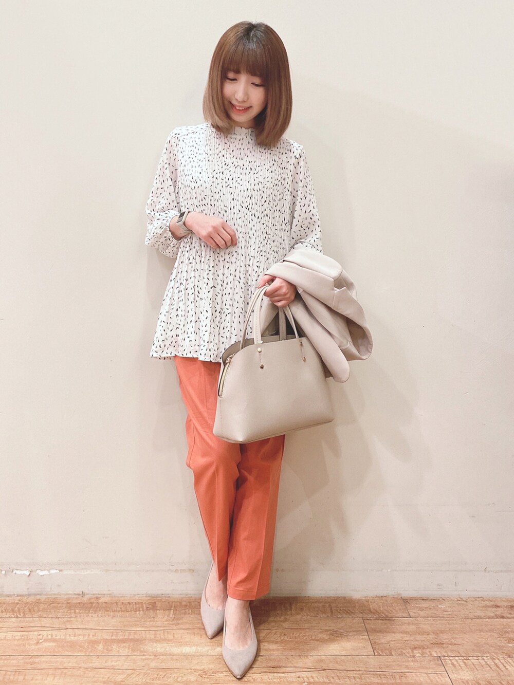 ベージュ系のテーラードジャケット、グレー系のトートバッグ、オレンジ系のその他パンツを着用したレディースの春コーディネートの5枚目の写真