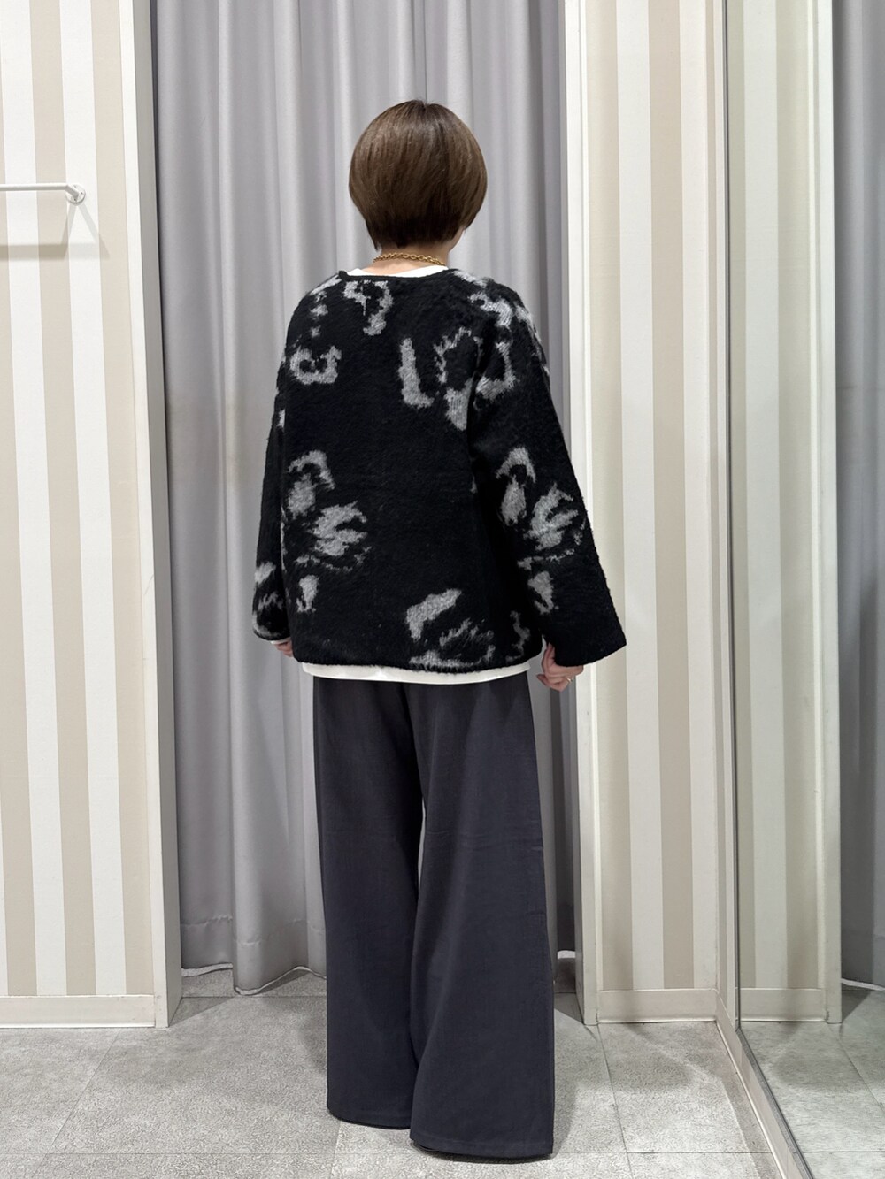 ホワイト系のTシャツ/カットソー、ブラック系のカーディガン/ボレロ、グレー系のその他パンツを着用したレディースの秋コーディネートの3枚目の写真