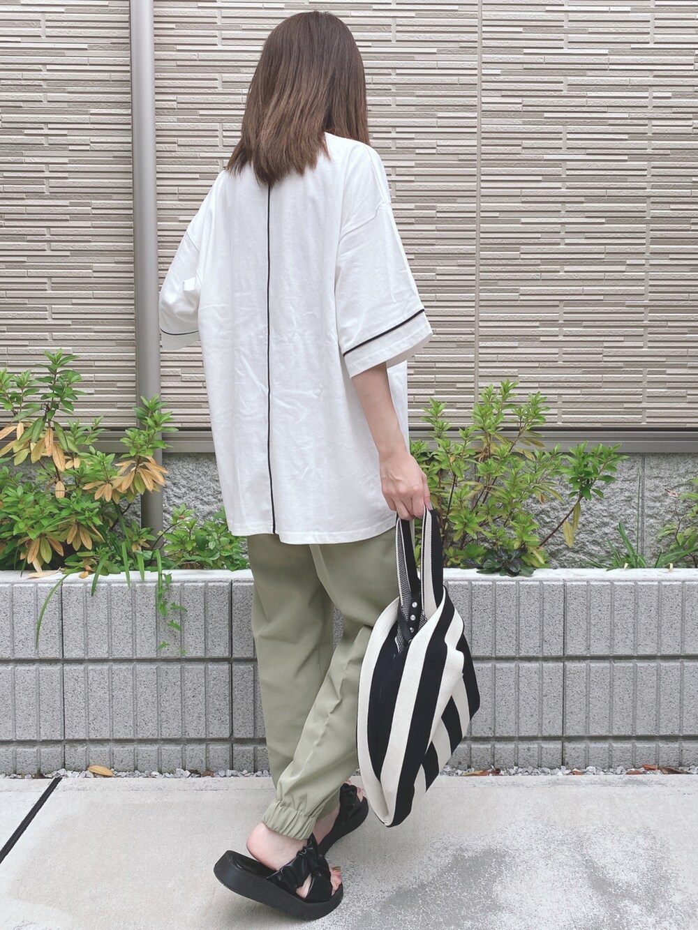 ホワイト系のTシャツ/カットソー、グリーン系のその他パンツ、ブラック系のサンダルを着用したレディースの夏コーディネートの2枚目の写真