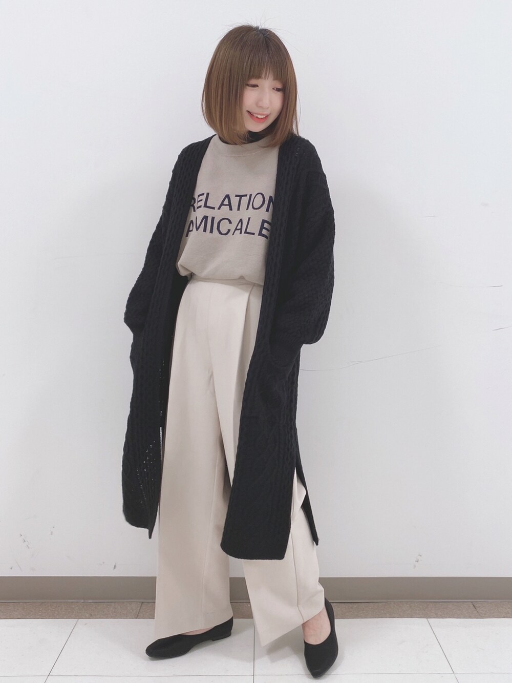 ベージュ系のニット/セーター、ベージュ系のその他パンツ、ブラック系のTシャツ/カットソーを着用したレディースの冬コーディネートの4枚目の写真