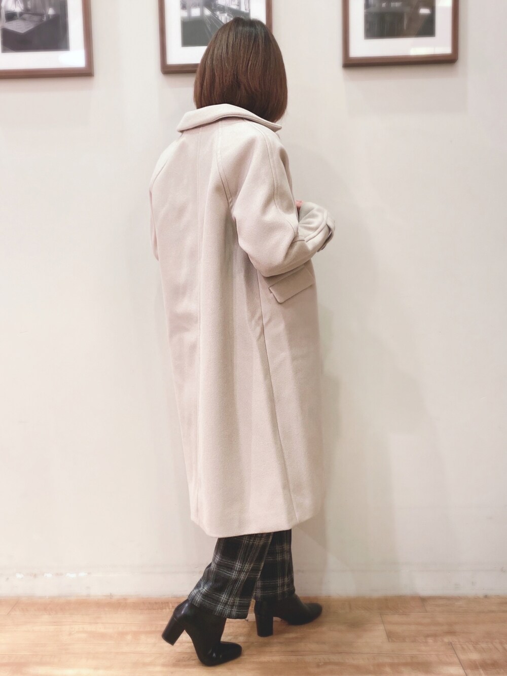 ブルー系のニット/セーター、ベージュ系のステンカラーコート、ブラック系のブーツを着用したレディースの秋コーディネートの2枚目の写真