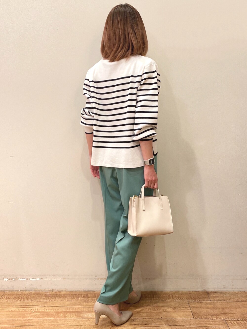 ブラック系のニット/セーター、ホワイト系のショルダーバッグ、グリーン系のその他パンツを着用したレディースの春コーディネートの2枚目の写真