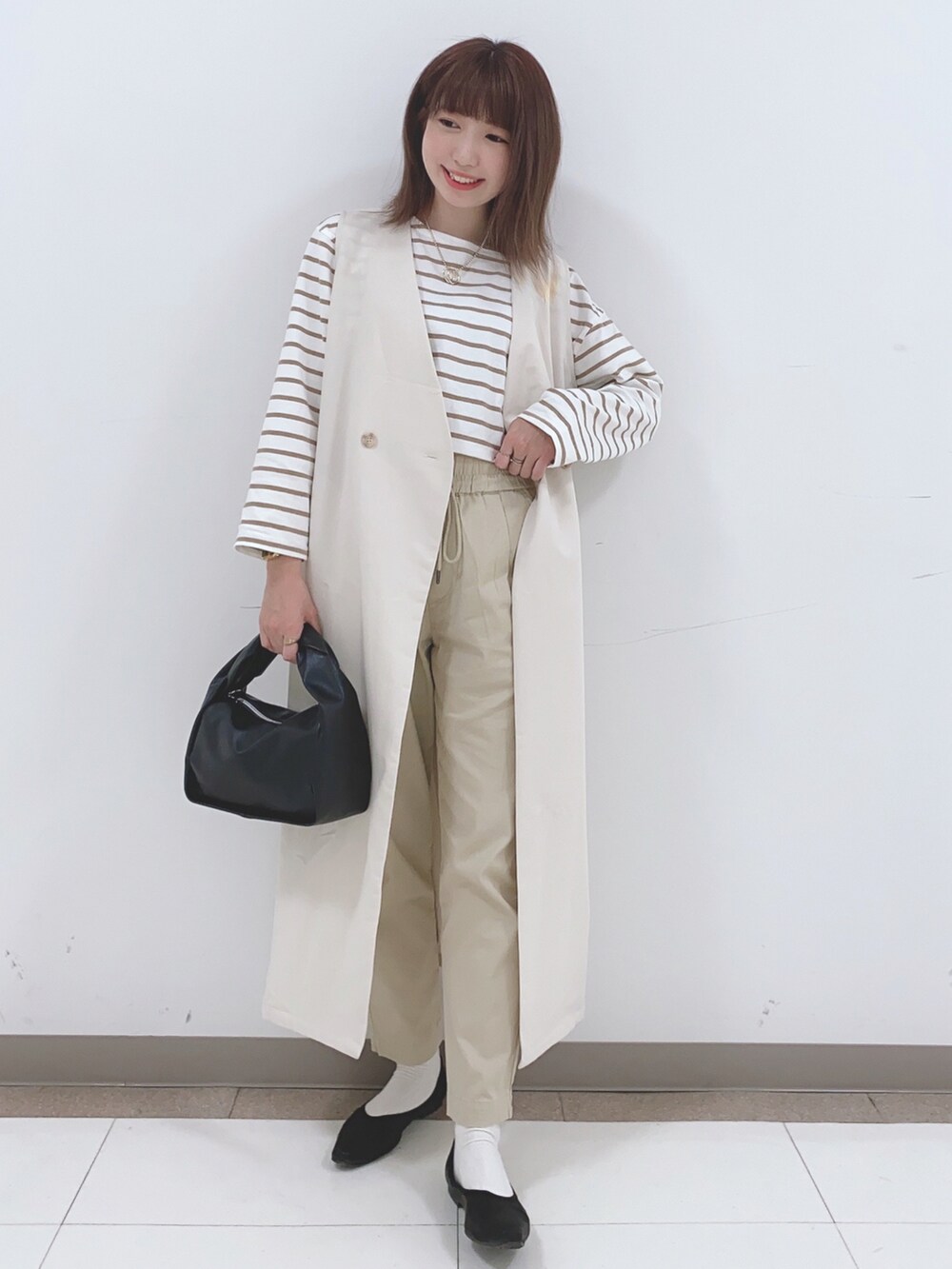 ベージュ系のベスト、ベージュ系のTシャツ/カットソー、ベージュ系のその他パンツを着用したレディースの春コーディネートの4枚目の写真