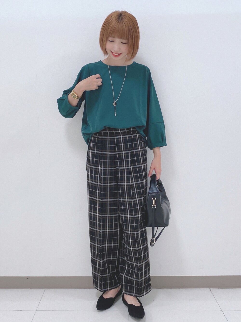 グリーン系のTシャツ/カットソー、ブラック系のパンツ、ブラック系のパンプスを着用したレディースの秋コーディネートの2枚目の写真