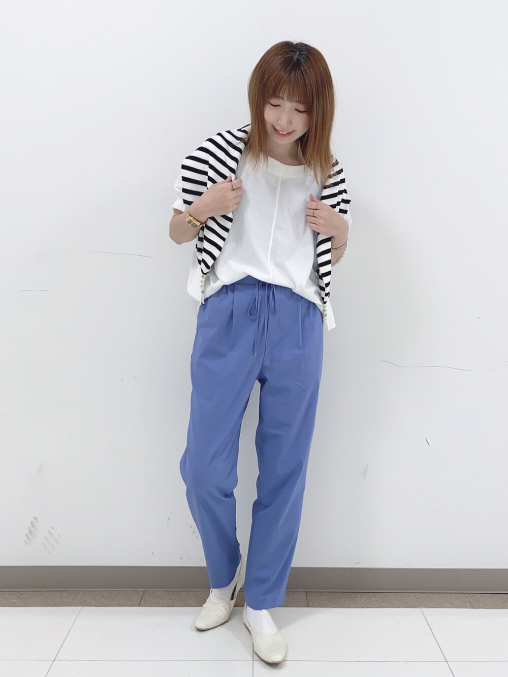 ホワイト系のTシャツ/カットソー、ブラック系のニット/セーター、ブルー系のその他パンツを着用したレディースの春コーディネートの4枚目の写真