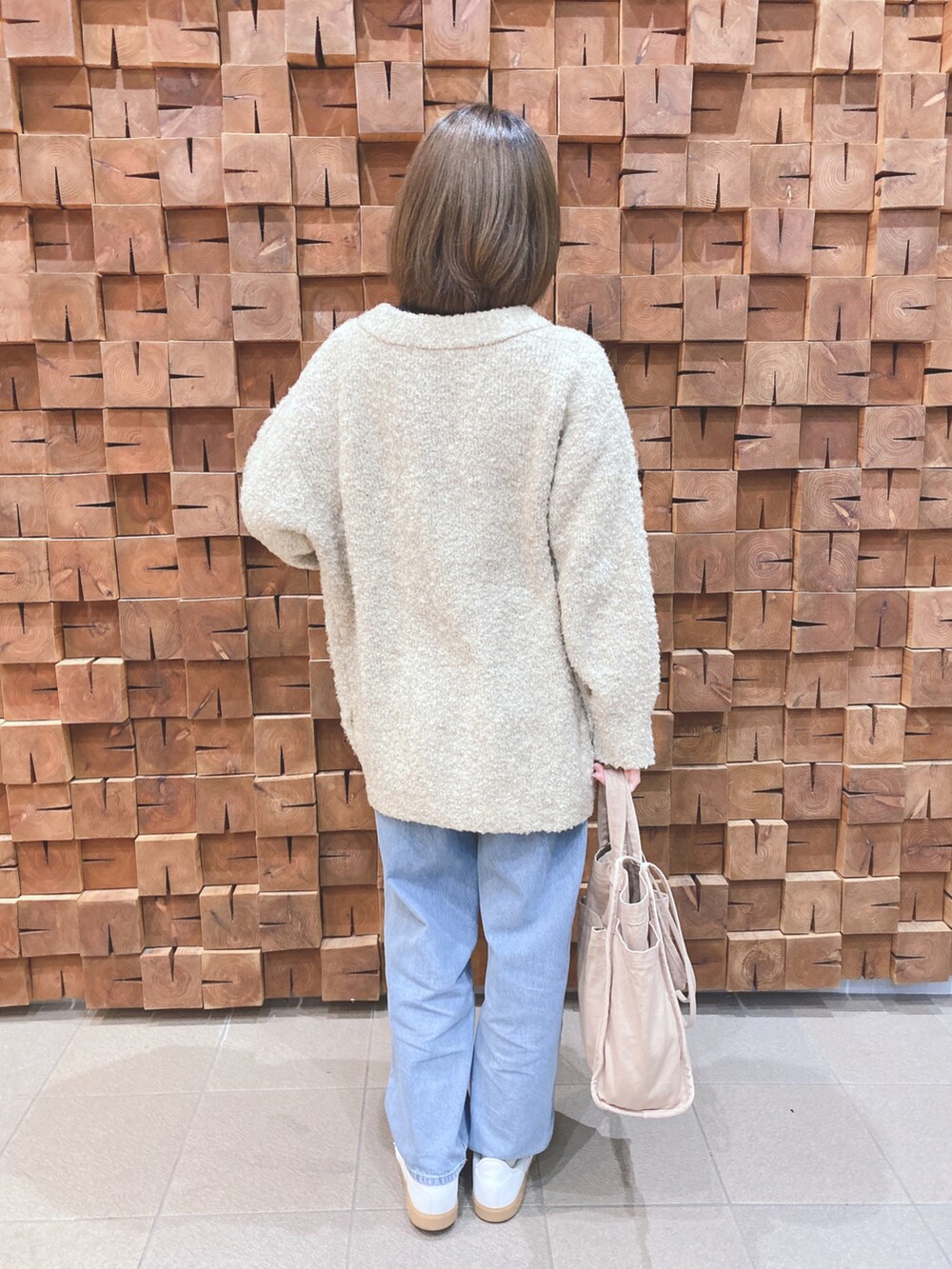 ベージュ系のカーディガン/ボレロ、ブラック系のニット/セーター、ブルー系のデニムパンツを着用したレディースの冬コーディネートの3枚目の写真