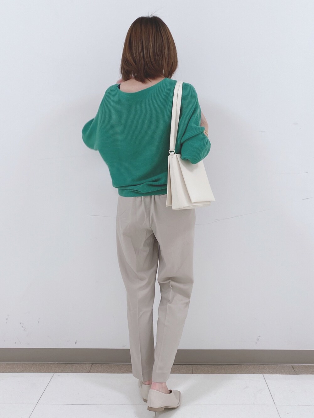 グリーン系のニット/セーター、ベージュ系のその他パンツ、ホワイト系のパンプスを着用したレディースの冬コーディネートの3枚目の写真