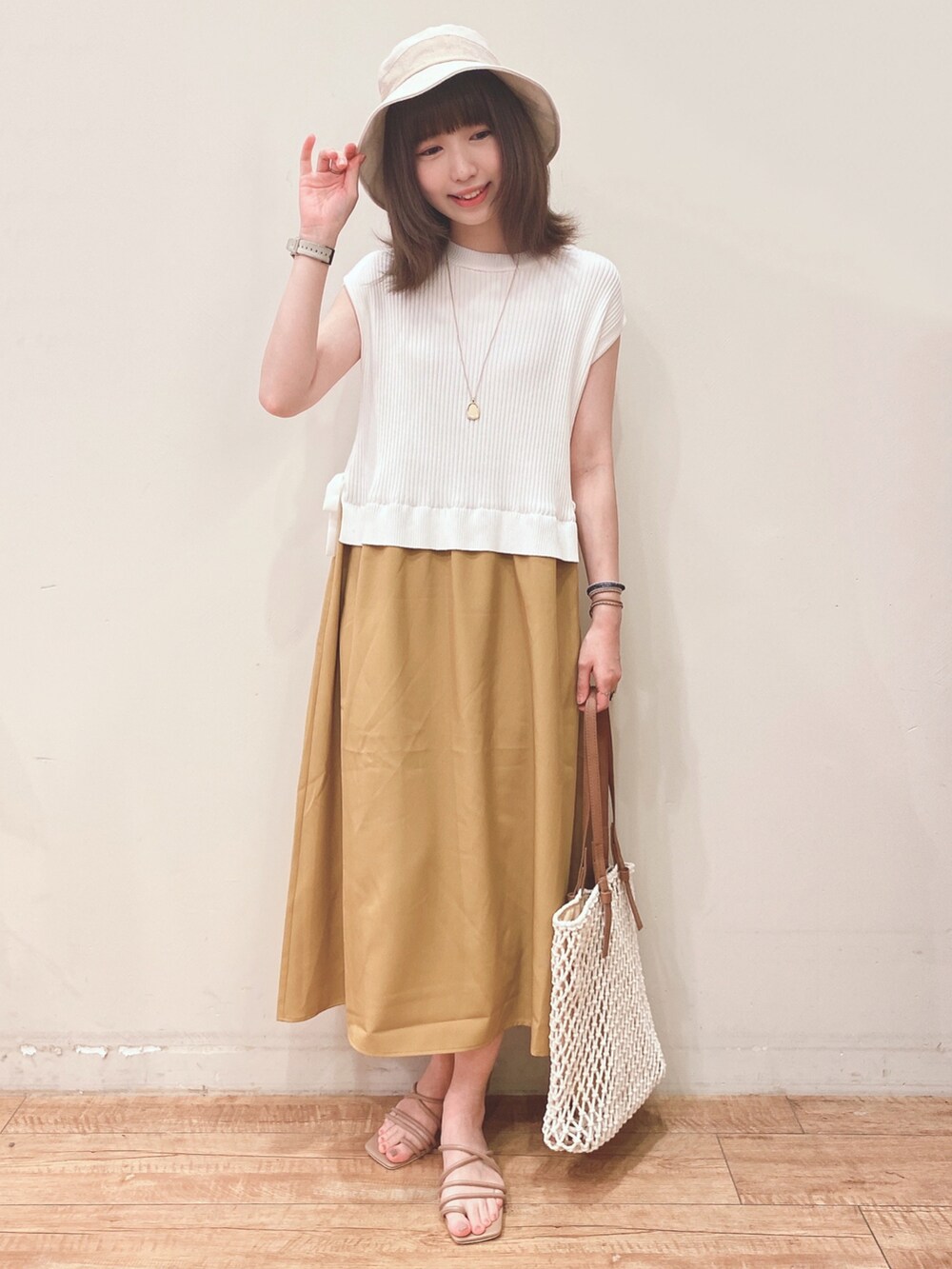 イエロー系のワンピース、ホワイト系のトートバッグ、ベージュ系のサンダルを着用したレディースの春コーディネートの4枚目の写真