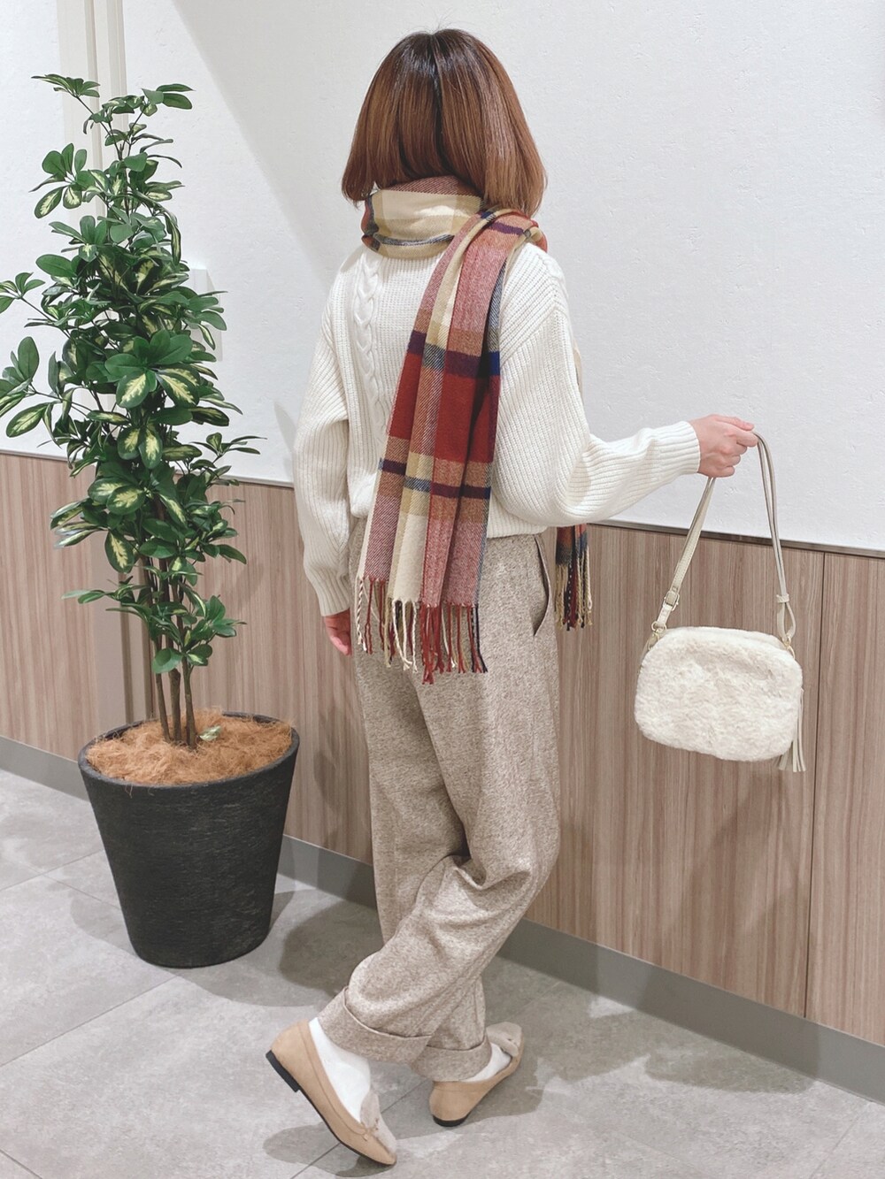 ホワイト系のニット/セーター、ベージュ系のその他パンツ、ホワイト系のショルダーバッグを着用したレディースの冬コーディネートの2枚目の写真