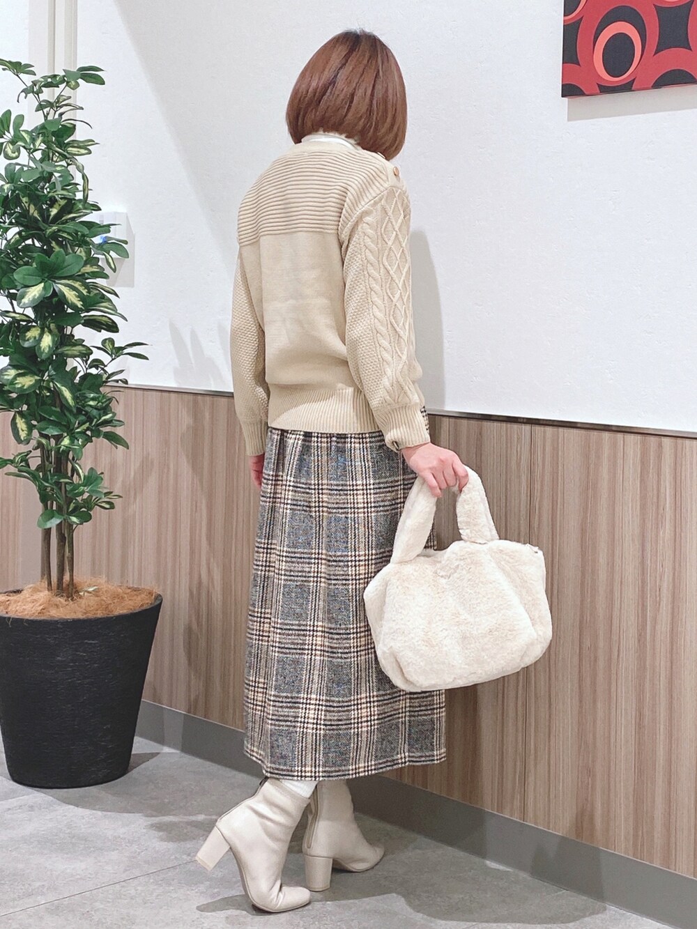 ベージュ系のニット/セーター、ホワイト系のTシャツ/カットソー、イエロー系のスカートを着用したレディースの冬コーディネートの2枚目の写真