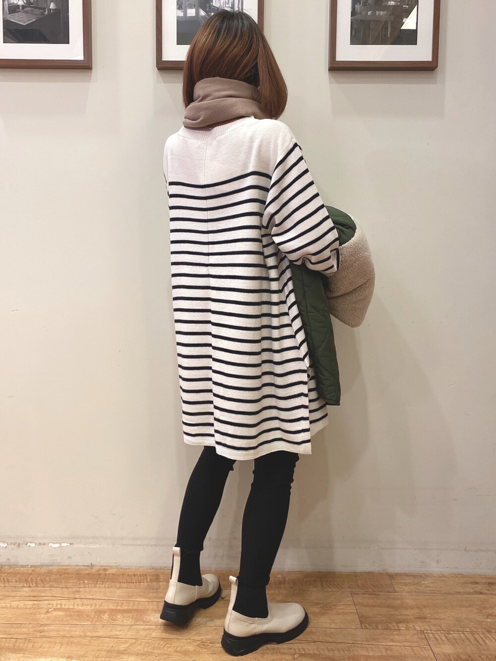 グリーン系のその他アウター、ブラック系のその他パンツ、ベージュ系のブーツを着用したレディースの冬コーディネートの2枚目の写真