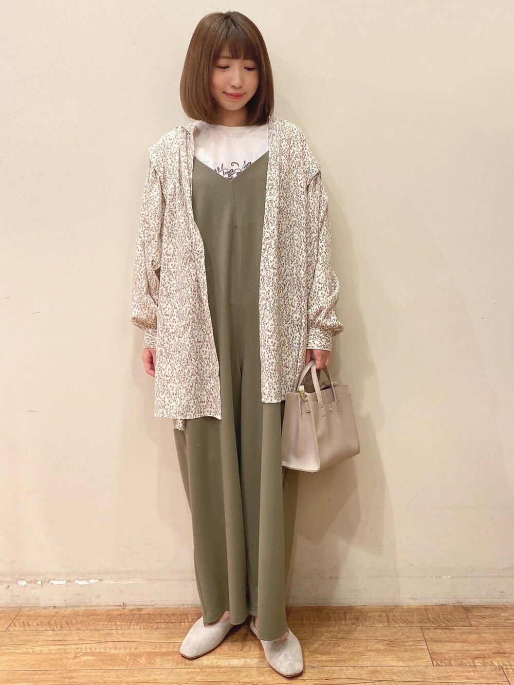 グリーン系のサロペット/オーバーオール、ベージュ系のチュニック、ホワイト系のTシャツ/カットソーを着用したレディースの春コーディネートの4枚目の写真