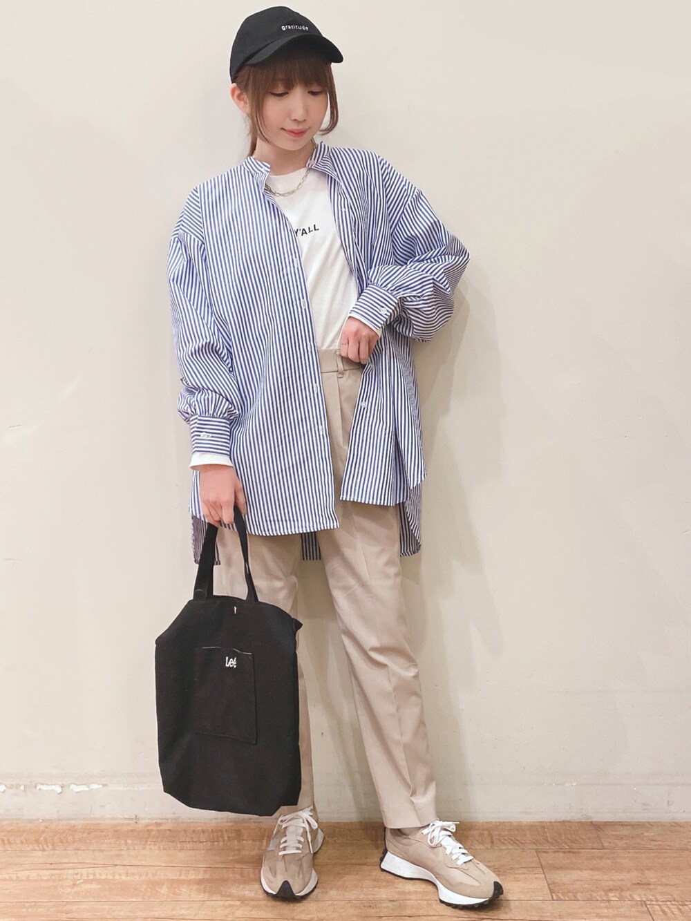 ホワイト系のTシャツ/カットソー、ブルー系のワンピース、ベージュ系のスニーカーを着用したレディースの春コーディネートの4枚目の写真