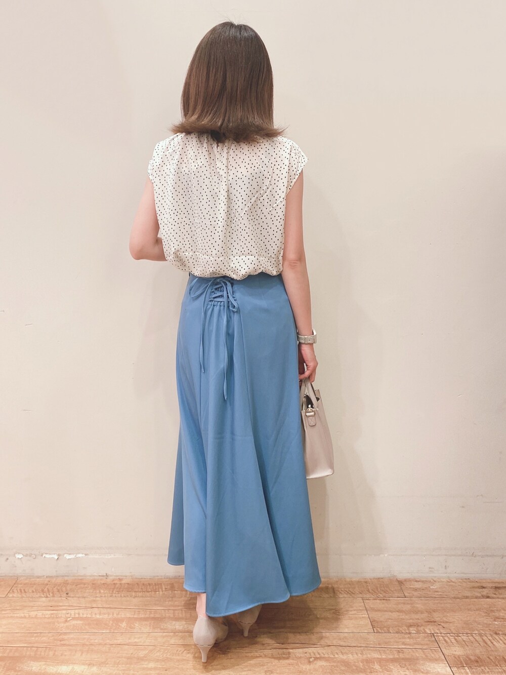 ベージュ系のシャツ/ブラウス、ブルー系のスカート、ベージュ系のパンプスを着用したレディースの春コーディネートの3枚目の写真