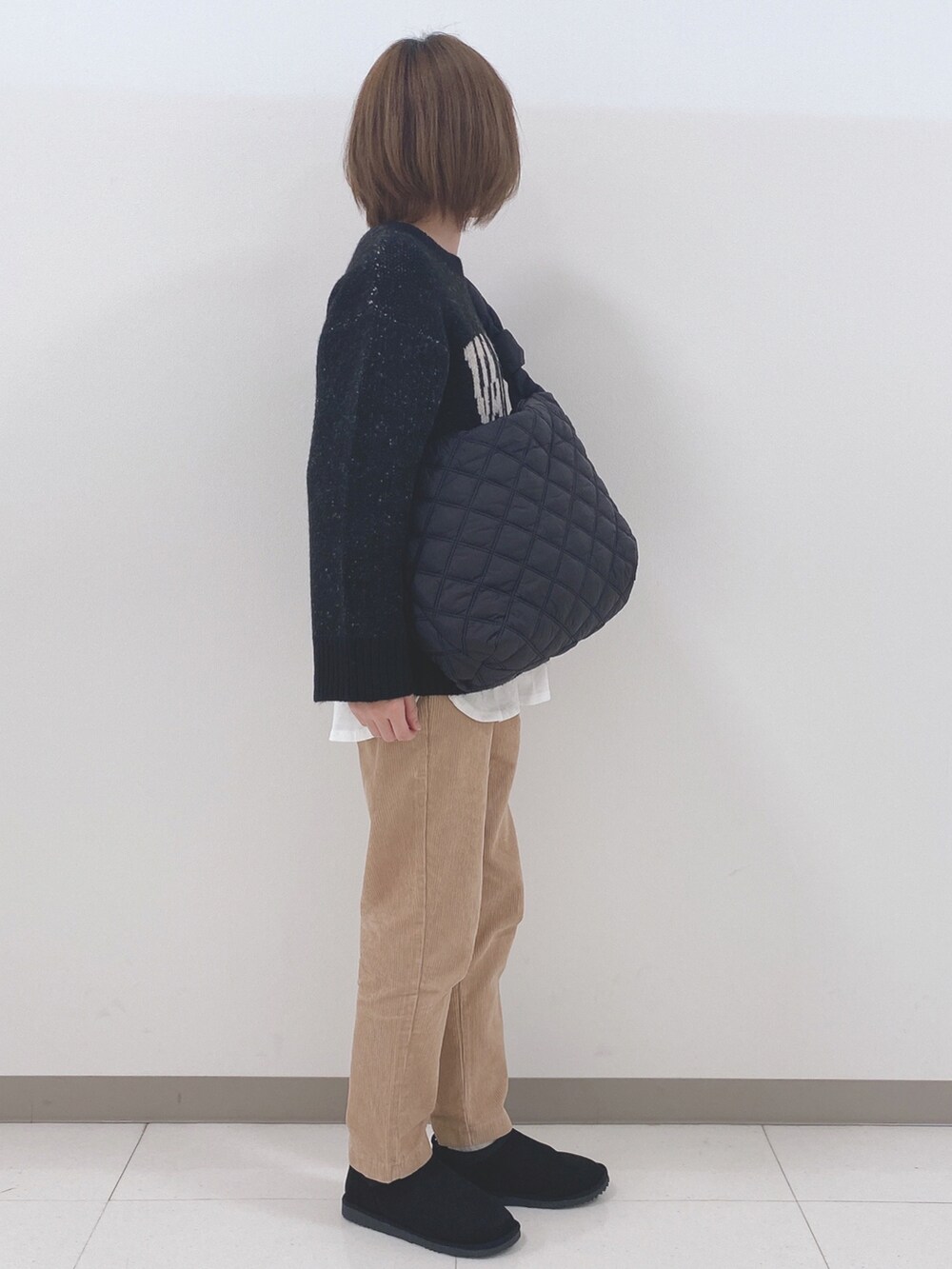 ブラック系のニット/セーター、ホワイト系のTシャツ/カットソー、イエロー系のその他パンツを着用したレディースの秋コーディネートの2枚目の写真