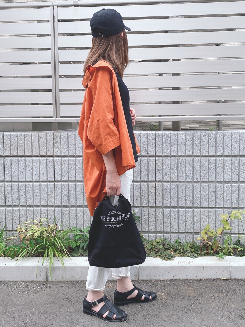 ブラック系のタンクトップ、オレンジ系のシャツ/ブラウス、ホワイト系のデニムパンツを着用したレディースの夏コーディネートの2枚目の写真