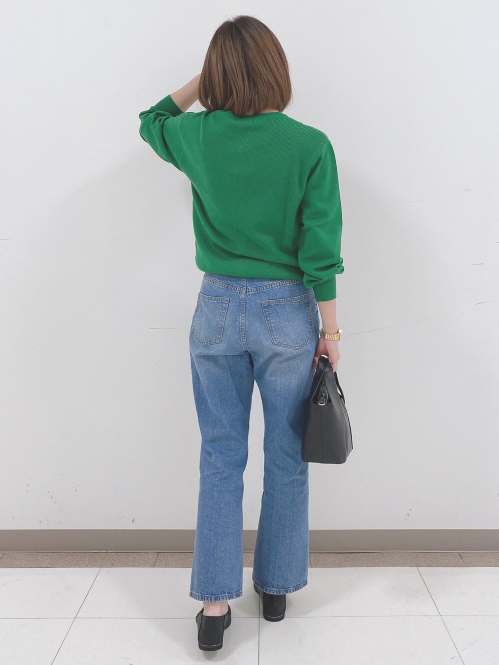 グリーン系のカーディガン/ボレロ、ブルー系のデニムパンツ、ブラック系のスニーカーを着用したレディースの冬コーディネートの3枚目の写真