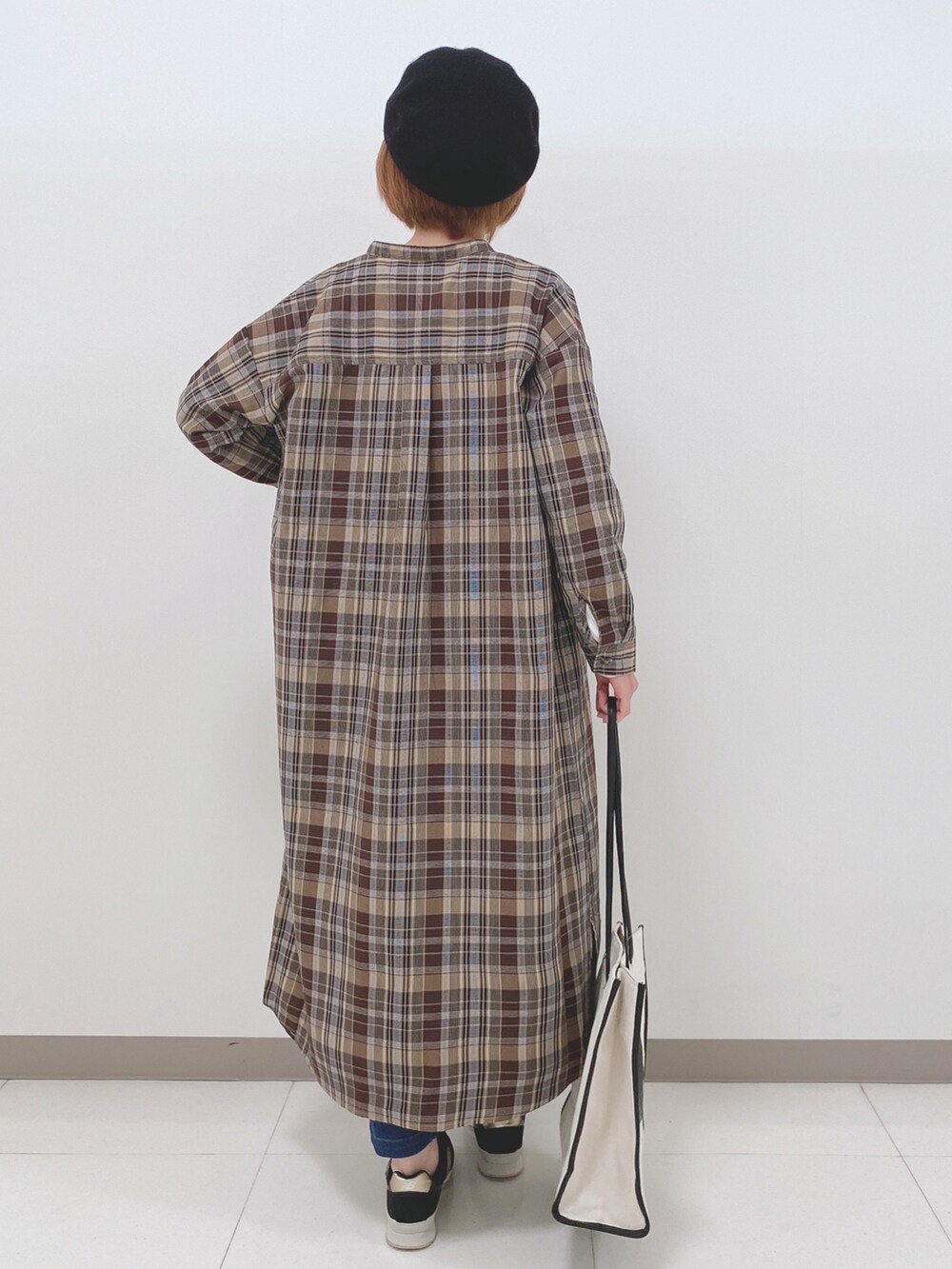 ベージュ系のワンピース、ホワイト系のTシャツ/カットソー、ブルー系のその他パンツを着用したレディースの秋コーディネートの3枚目の写真