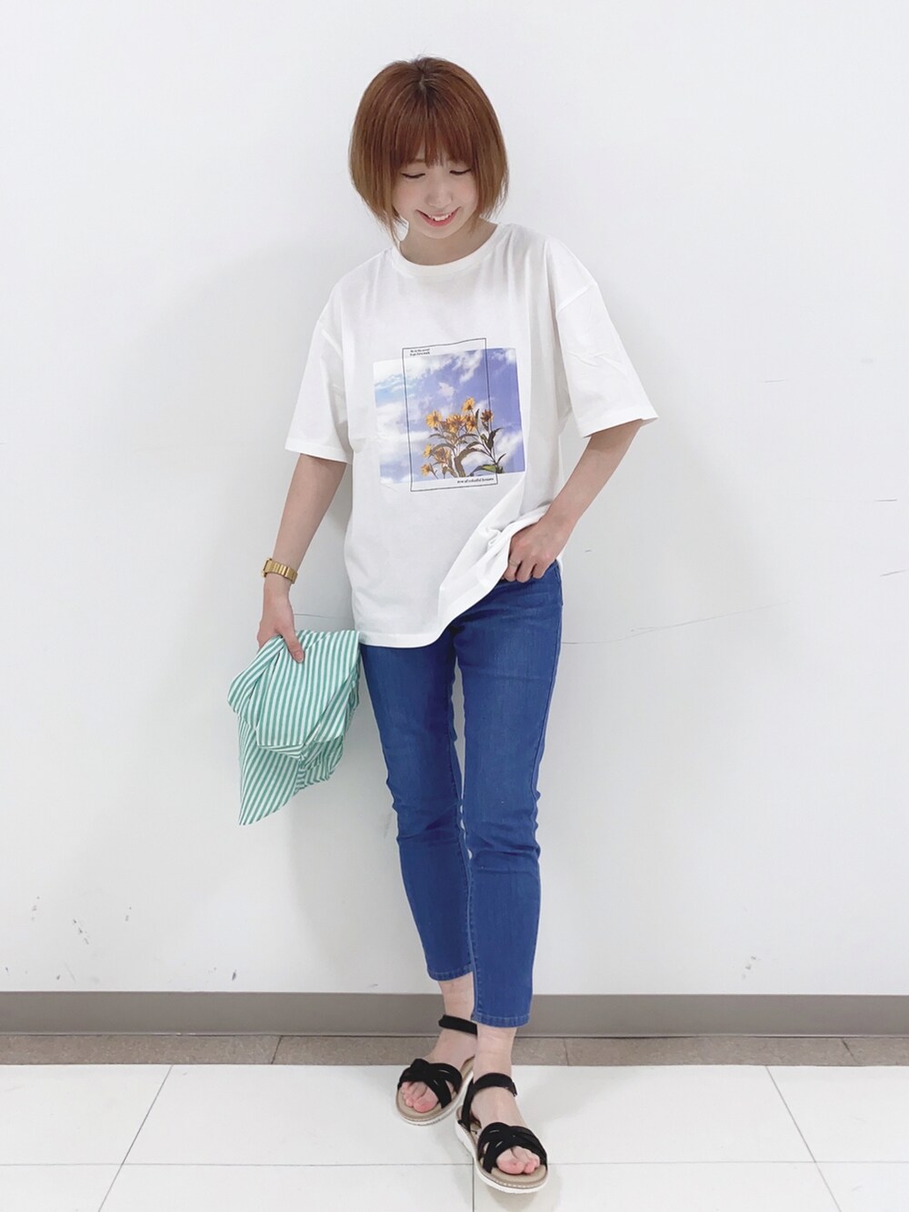 グリーン系のシャツ/ブラウス、ホワイト系のTシャツ/カットソー、ブルー系のデニムパンツを着用したレディースの春コーディネートの4枚目の写真