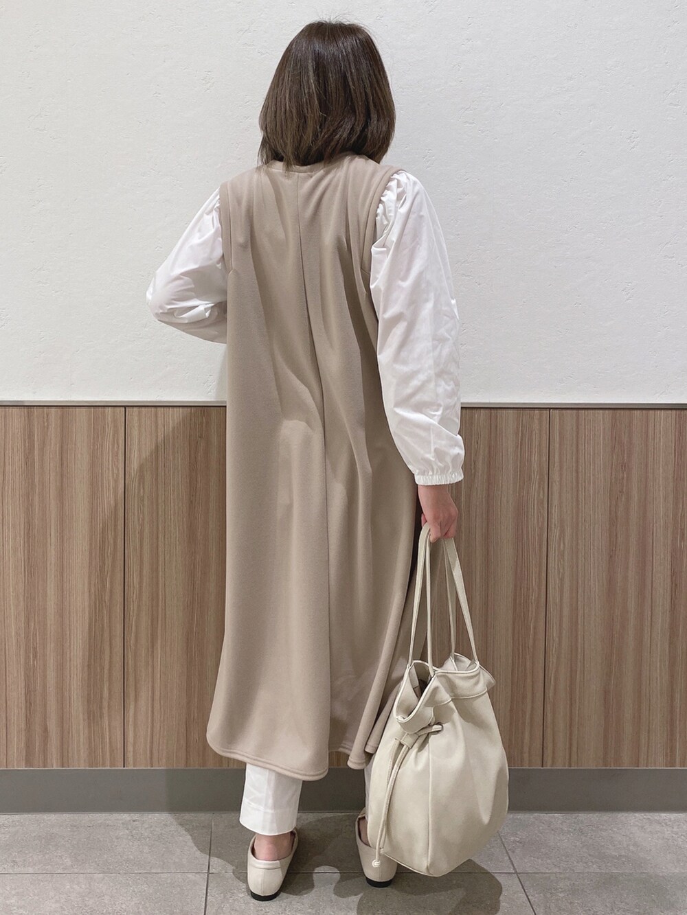 ベージュ系のワンピース、ホワイト系のドレスシューズ、ベージュ系のトートバッグを着用したレディースの春コーディネートの3枚目の写真