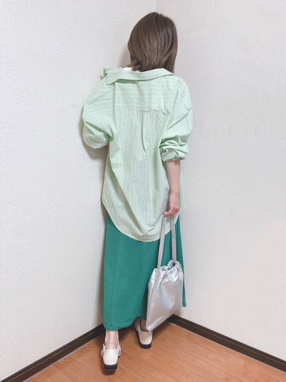 ホワイト系のTシャツ/カットソー、グリーン系のスカート、グリーン系のシャツ/ブラウスを着用したレディースの春コーディネートの3枚目の写真