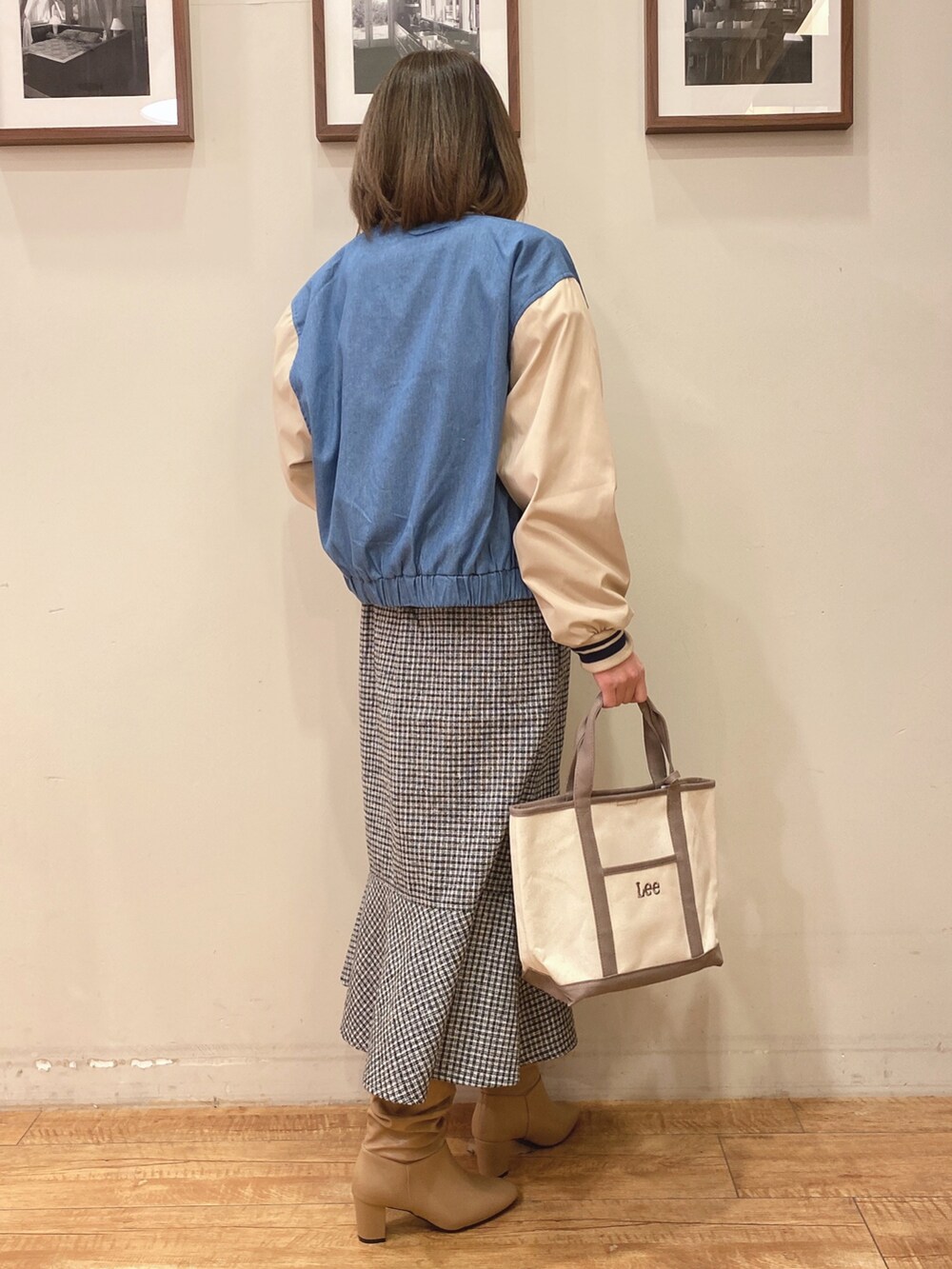 ホワイト系のスウェット、ブルー系のブルゾン、ブラック系のスカートを着用したレディースの冬コーディネートの2枚目の写真