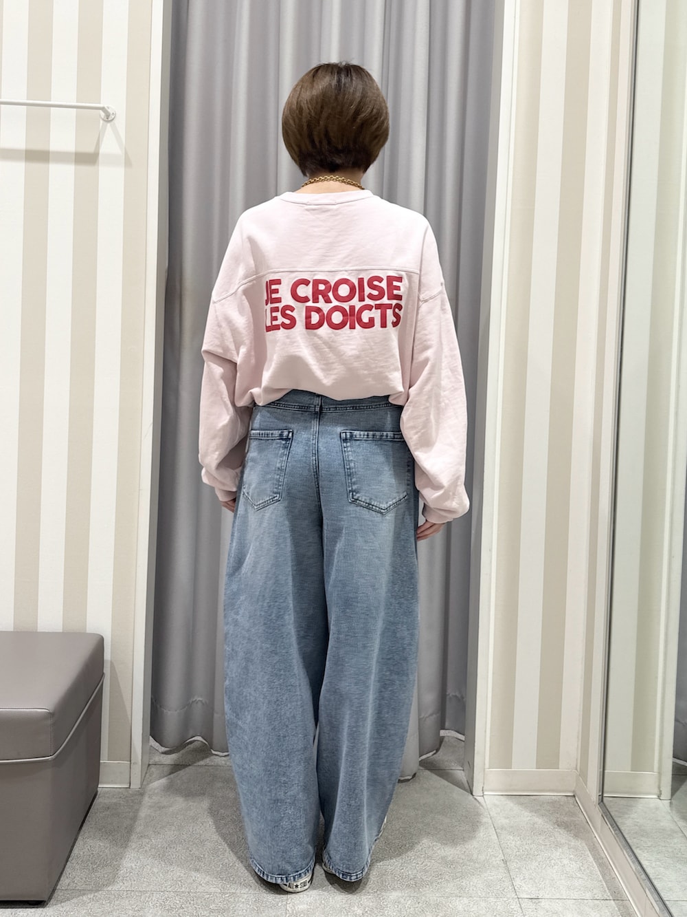 ピンク系のスウェット、ホワイト系のその他アウター、ブルー系のデニムパンツを着用したレディースの秋コーディネートの5枚目の写真