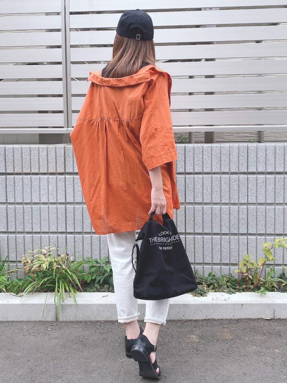 ブラック系のタンクトップ、オレンジ系のシャツ/ブラウス、ホワイト系のデニムパンツを着用したレディースの夏コーディネートの3枚目の写真