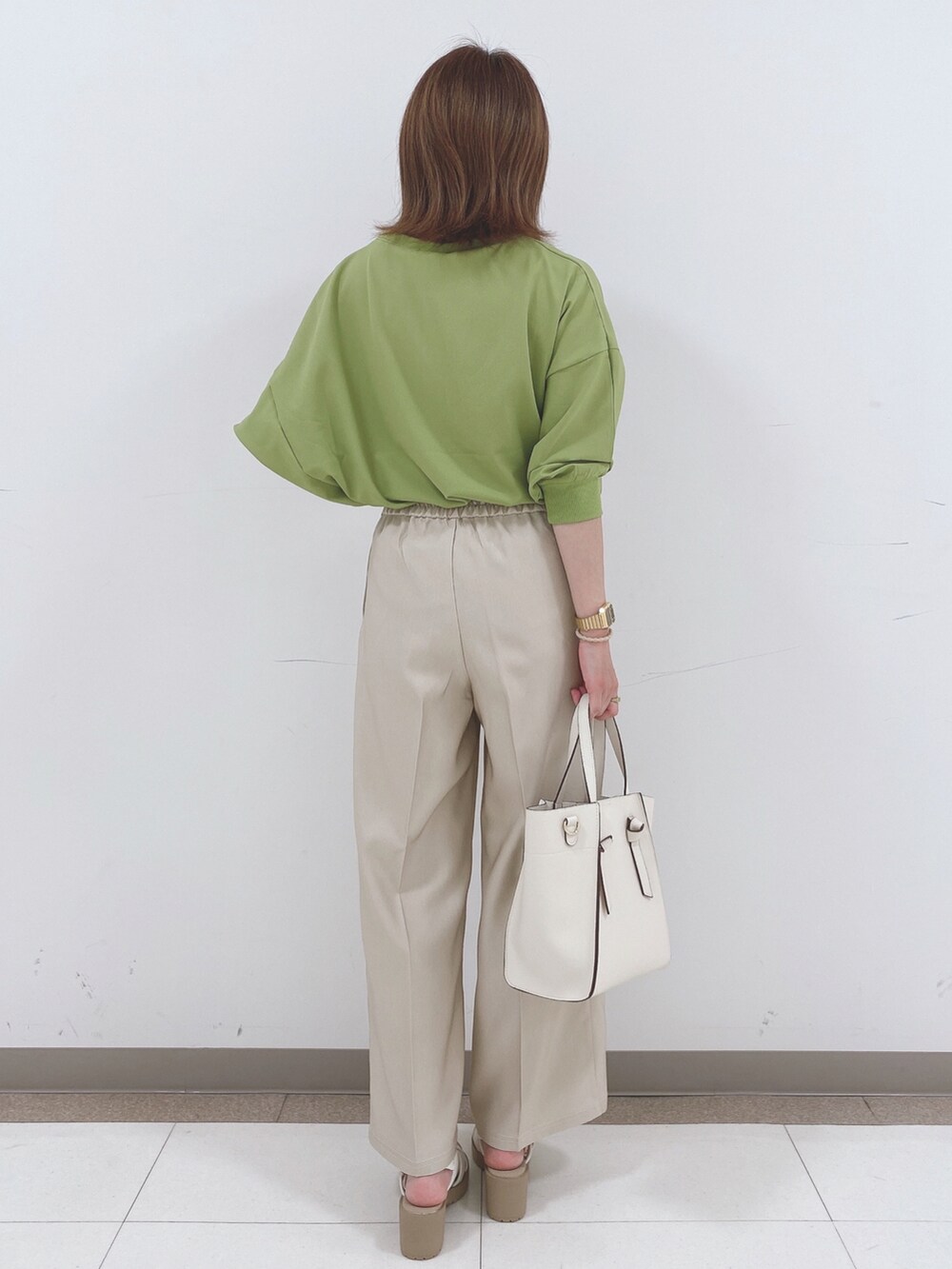 グリーン系のシャツ/ブラウス、ベージュ系のその他パンツ、ホワイト系のサンダルを着用したレディースの春コーディネートの3枚目の写真