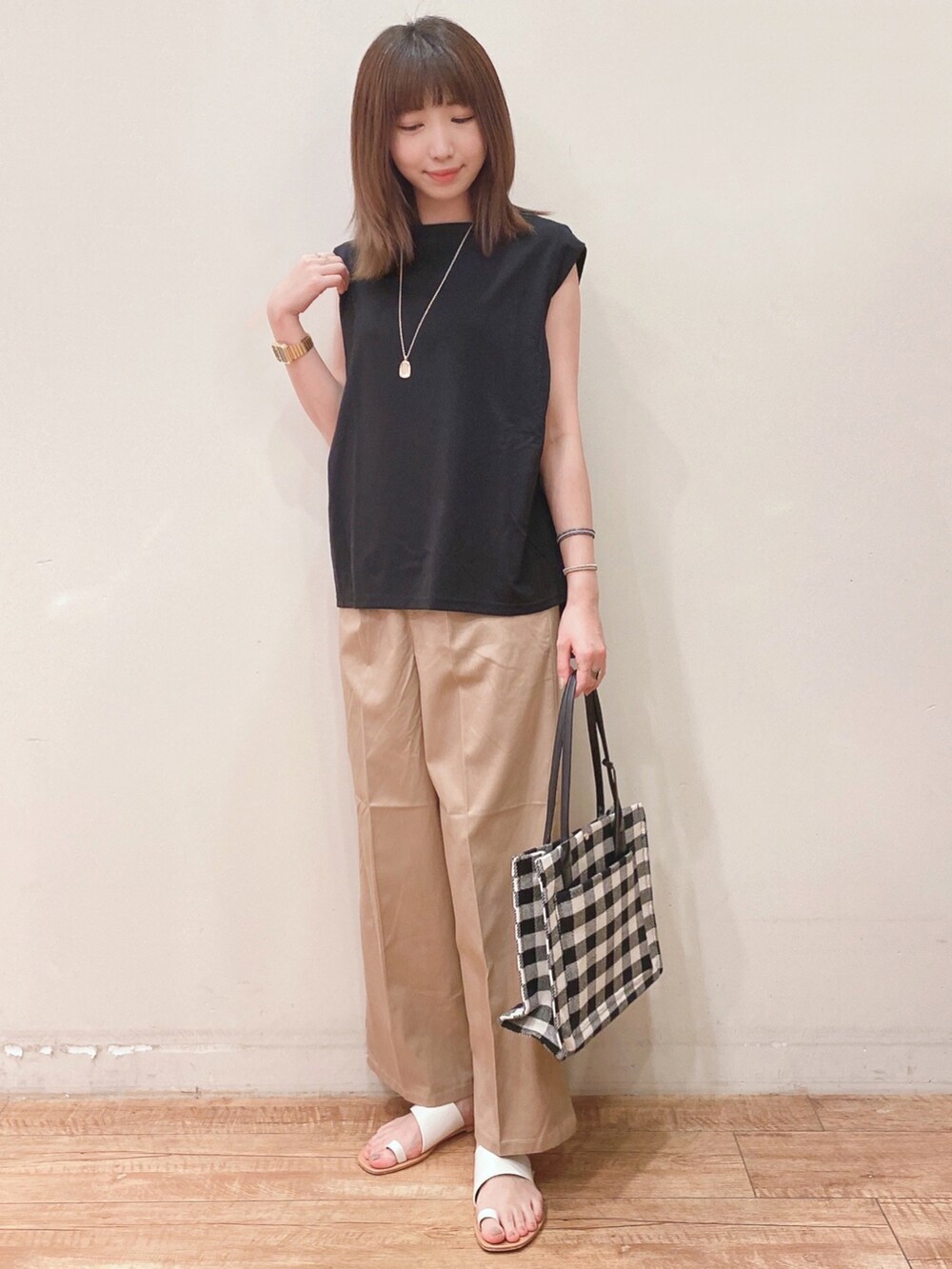 ブラック系のTシャツ/カットソー、ベージュ系のその他パンツ、ホワイト系のサンダルを着用したレディースの夏コーディネートの4枚目の写真
