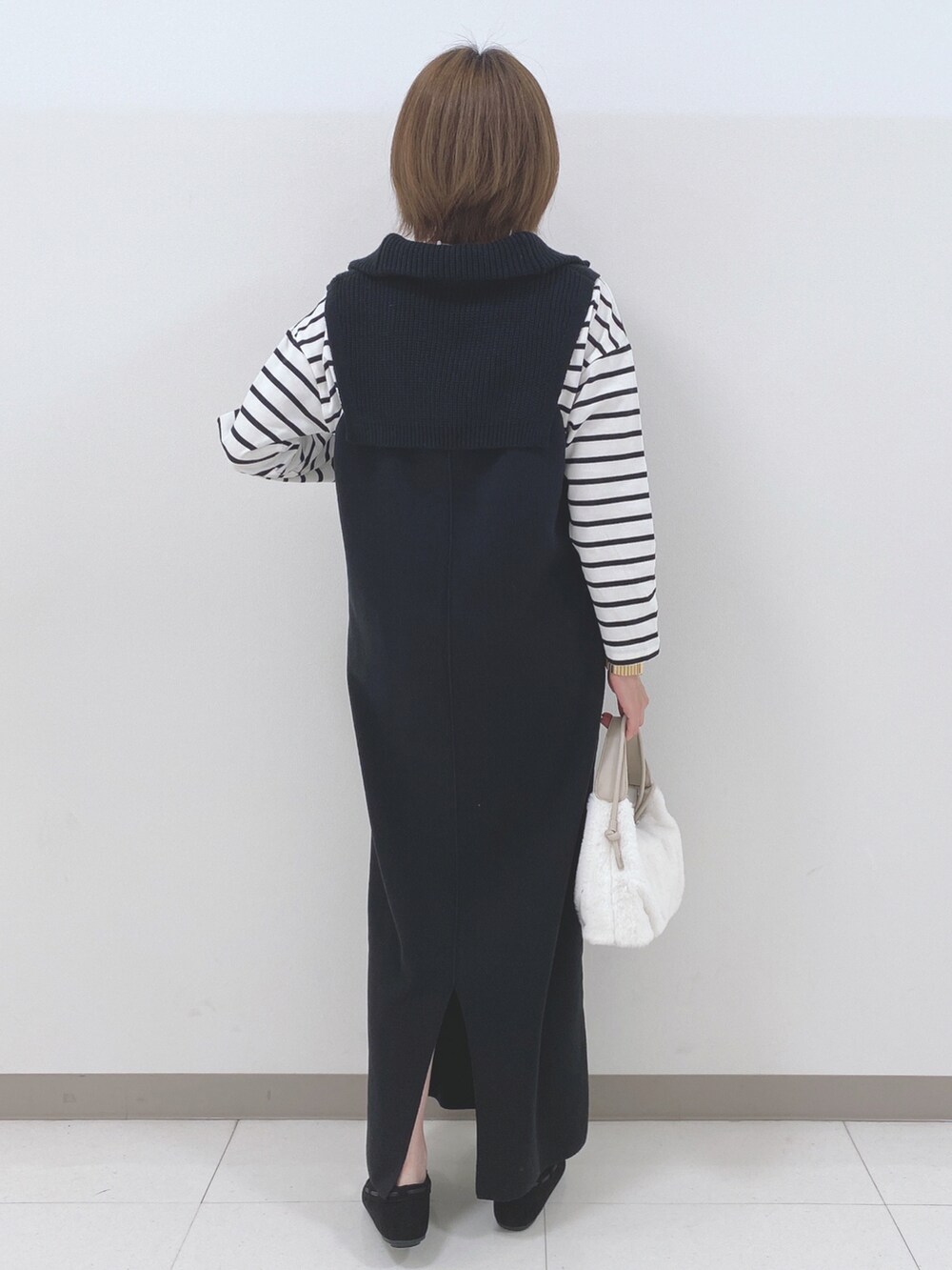 ブラック系のワンピース、ホワイト系のTシャツ/カットソー、ホワイト系のショルダーバッグを着用したレディースの秋コーディネートの3枚目の写真