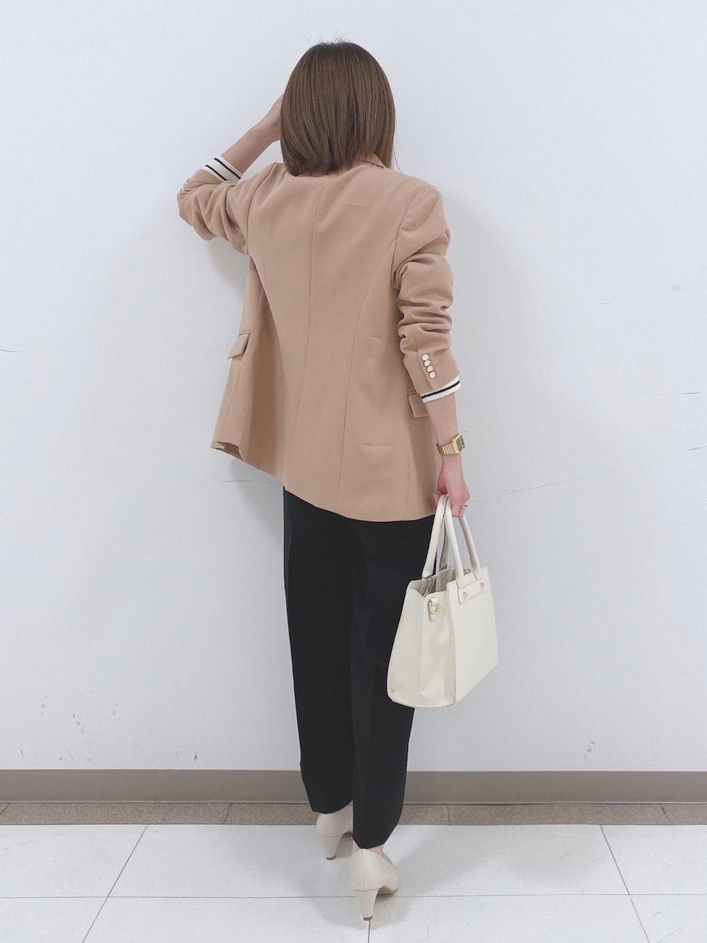 ベージュ系のテーラードジャケット、ホワイト系のニット/セーター、ブラック系のその他パンツを着用したレディースの冬コーディネートの3枚目の写真