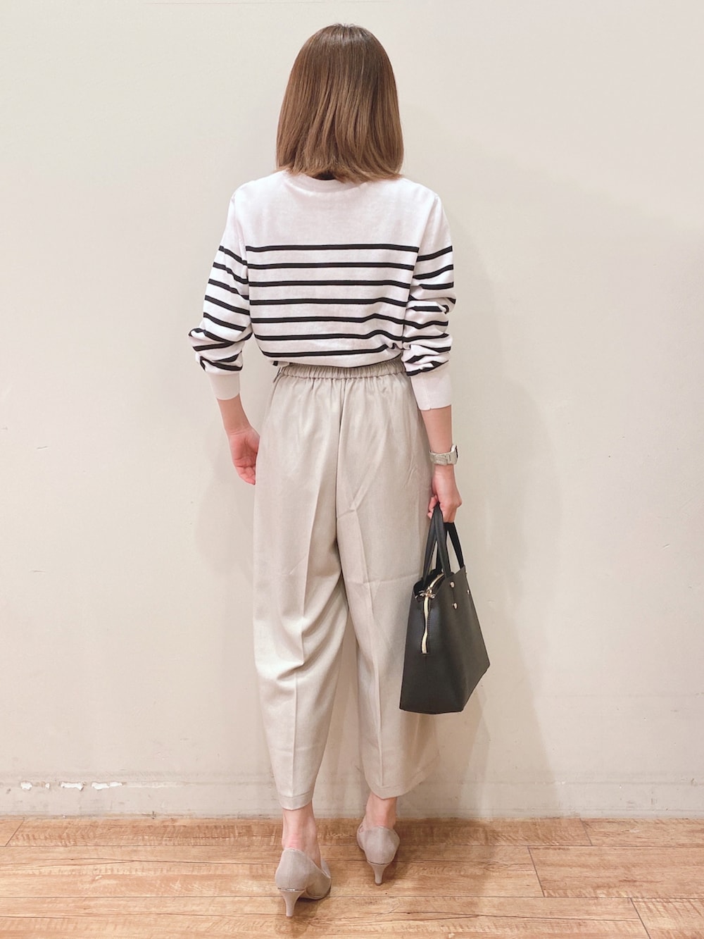 ホワイト系のカーディガン/ボレロ、ベージュ系のその他パンツ、ブラック系のトートバッグを着用したレディースの春コーディネートの3枚目の写真