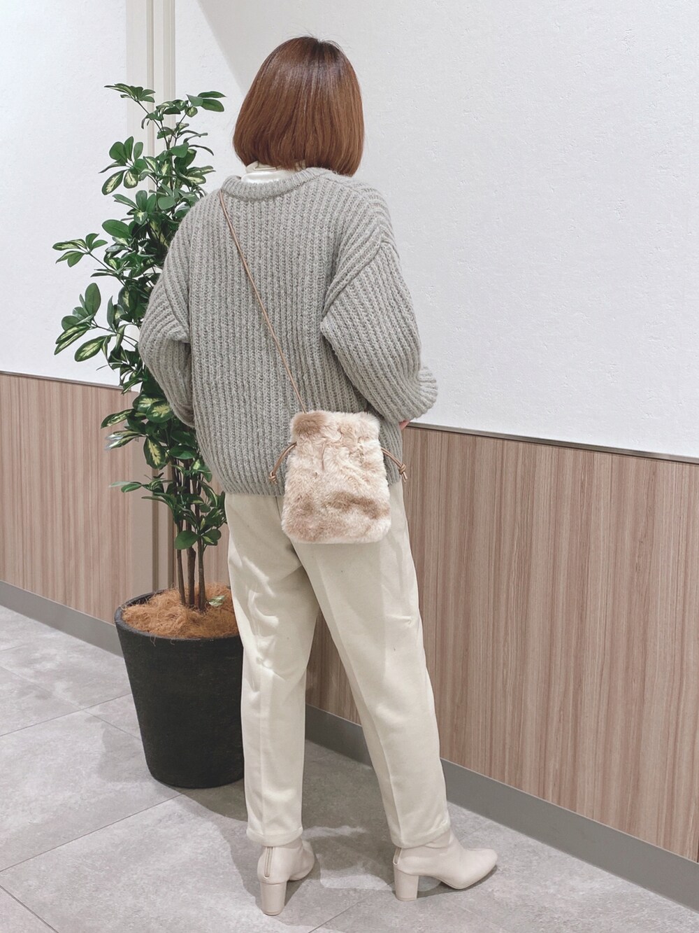 グリーン系のニット/セーター、ベージュ系のショルダーバッグ、ホワイト系のTシャツ/カットソーを着用したレディースの秋コーディネートの2枚目の写真